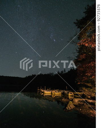 Shirakoma Pond along the Fairy Tale Highway in Kita Yatsugatake, Minamisaku District, Nagano Prefecture / Reflection of stars and starry sky in Shirakoma Forest and a small boat 92735876