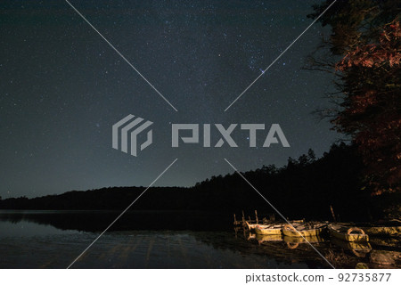 Shirakoma Pond along the Fairy Tale Highway in Kita Yatsugatake, Minamisaku District, Nagano Prefecture / Reflection of stars and starry sky in Shirakoma Forest and a small boat 92735877