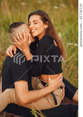 Couple in a field. Woman in a black blouse. Sunset background. Couple in a field. Woman in a black blouse. Sunset background. 92736129