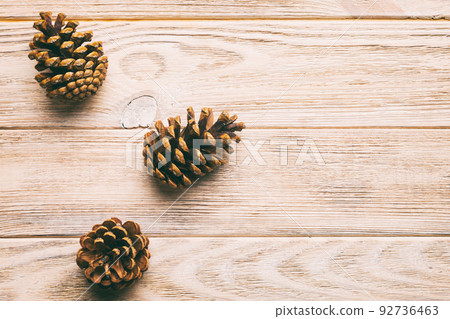 Christmas pine cones on colored paper border composition. Christmas, New Year, winter concept. Flat lay, top view, copy space Christmas pine cones on colored paper border composition. Christmas, New Year, winter concept. Flat lay, top view, copy space 92736463