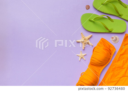 Woman swimwear and beach accessories flat lay top view on colored background Summer travel concept. bikini swimsuit, straw hat and seasheels. Copy space Top view 92736480