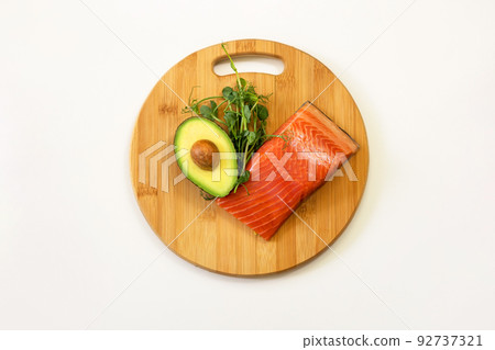 Ingredients of healthy food. Fish, avocado, micro green pea sprouts on a wooden cutting board. Ketogenic low carbs diet concept. Ingredients of healthy food. Fish, avocado, micro green pea sprouts on a wooden cutting board. Ketogenic low carbs diet concept. 92737321