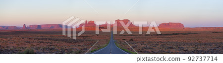 Scenic Road in the Dry Desert with Red Rocky Mountains in Background. 92737714