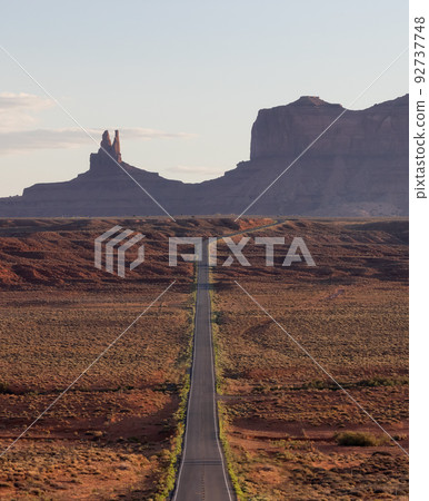 Scenic Road in the Dry Desert with Red Rocky Mountains in Background. 92737748