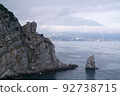 A rock in the sea with an eagle on top and a sail-shaped rock at the foot 92738715
