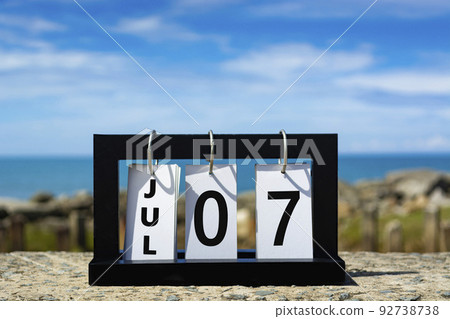 Jul 07 calendar date text on wooden frame with blurred background of ocean. 92738738