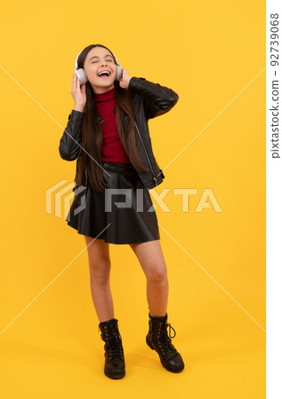 online education. back to school. happy teen girl in headphones full length. music lover online education. back to school. happy teen girl in headphones full length. music lover 92739068