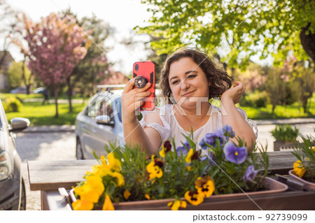 Smiling woman on street using mobile and having video call. Smiling woman on street using mobile and having video call. 92739099