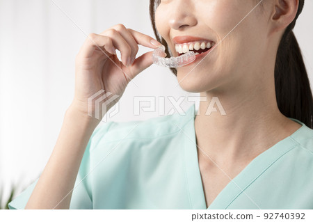 Woman holding a mouthpiece with one hand Woman holding a mouthpiece with one hand 92740392