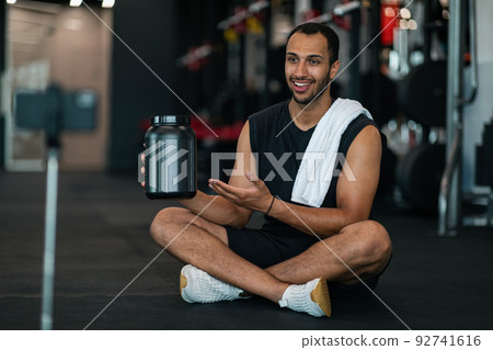 Sporty African American Man Recording Video Content While Sitting At Gym Sporty African American Man Recording Video Content While Sitting At Gym 92741616