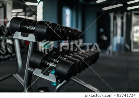 Sports equipment concept. Set of dumbbells placed on the rack in gym Sports equipment concept. Set of dumbbells placed on the rack in gym 92741724