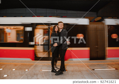 Couple holding hands while walking near wagon in subway. Couple is traveling and moving around the city using the metro. Traveling. Metro in Warsaw. 92741821