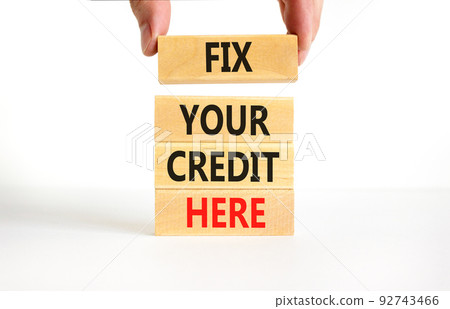 Fix your credit here symbol. Concept words Fix your credit here on wooden blocks on a beautiful white table white background. Businessman hand. Business, finacial and fix your credit here concept. 92743466