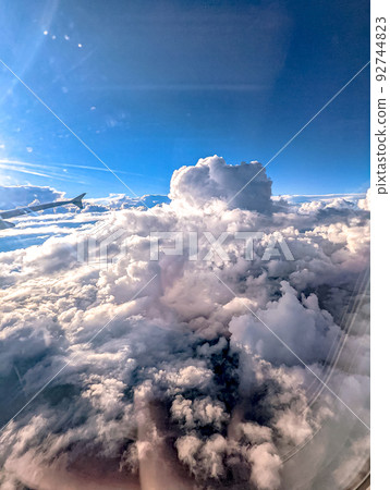 Clouds and sky as seen through window of an aircraft 92744823