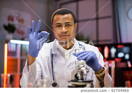 Modern medical research laboratory: portrait of scientist working, using microscope Modern medical research laboratory: portrait of scientist working, using microscope 92744968