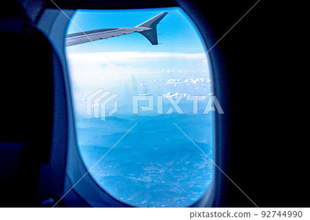 View of blue cloudy sky from airplane window View of blue cloudy sky from airplane window 92744990