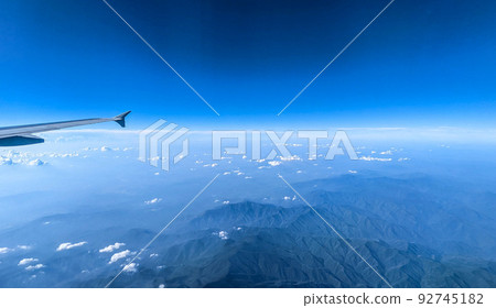 Clouds and sky as seen through window of an aircraft Clouds and sky as seen through window of an aircraft 92745182