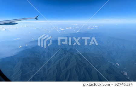Clouds and sky as seen through window of an aircraft 92745184