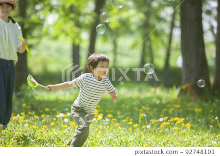 boy chasing soap bubbles boy chasing soap bubbles 92748101