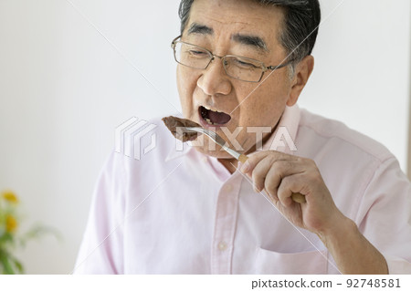 Man in his 70s eating steak Man in his 70s eating steak 92748581