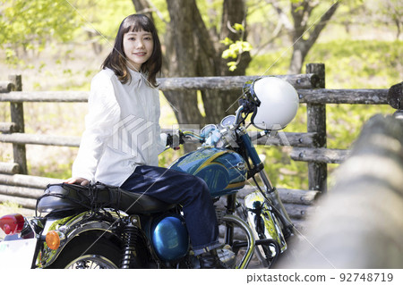 Bike girl image Young woman straddling a motorcycle 92748719