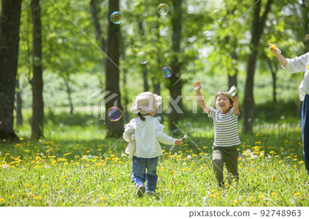 Kindergartener playing with soap bubbles 92748963