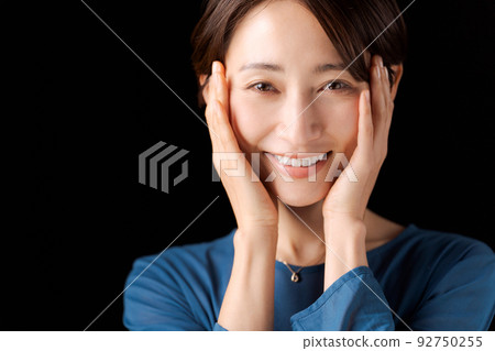 一個 30 多歲的女人的肖像,黑色背景 一個 30 多歲的女人的肖像,黑色背景 92750255
