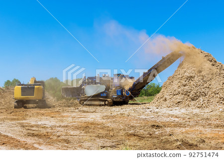 This wood chipper machine has a mulch conveyor as well as a conveyor for shredding roots. 92751474