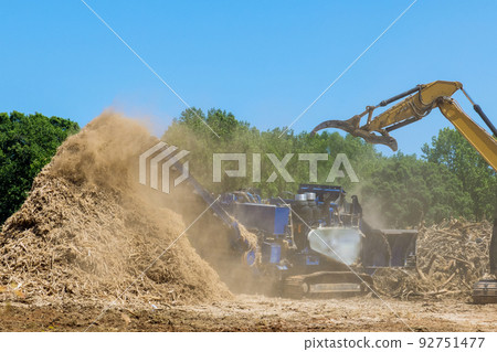 In the shredding machine of a work conveyor, wood chips are produced from wood roots in a stationary industrial shredder In the shredding machine of a work conveyor, wood chips are produced from wood roots in a stationary industrial shredder 92751477