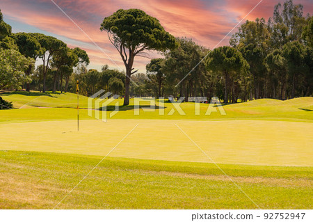Flag and hole on a golf course on a sunny day 92752947