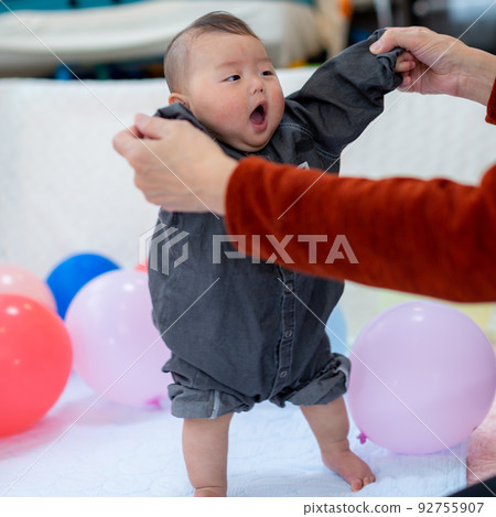 Baby standing with support Baby standing with support 92755907