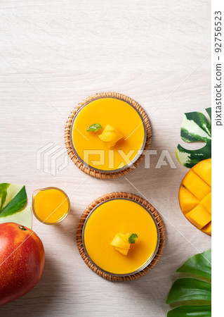 Delicious mango panna cotta mousse pudding on white table background. Delicious mango panna cotta mousse pudding on white table background. 92756523