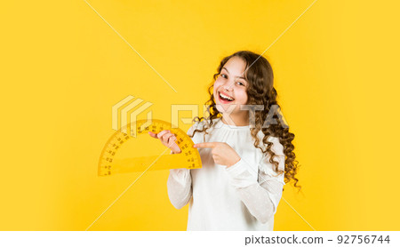 Excited about knowledge. mathematics and people concept. geometric shapes. modern education concept. girl with protractor and triangle ruler. back to school. STEM school disciplines. copy space Excited about knowledge. mathematics and people concept. geometric shapes. modern education concept. girl with protractor and triangle ruler. back to school. STEM school disciplines. copy space 92756744