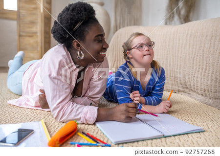 A girl having a lesson with her teacher and looking thoughtful A girl having a lesson with her teacher and looking thoughtful 92757268