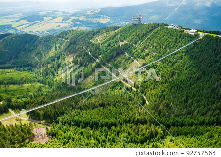 Sky Bridge 721 is the longest suspension bridge between two hills in the forest, Dolni Morava, Czech Republic . One way footbridge in touristic place in the forest in summer. Sky Bridge 721 is the longest suspension bridge between two hills in the forest, Dolni Morava, Czech Republic . One way footbridge in touristic place in the forest in summer. 92757563