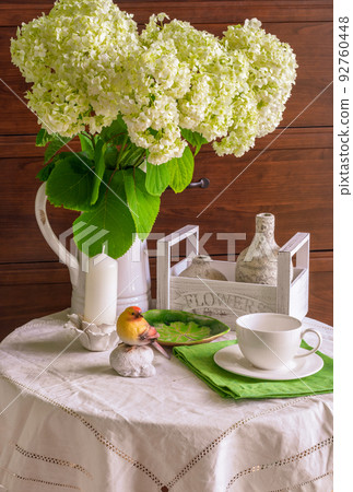 White hydrangea flowers in a jug on the table White hydrangea flowers in a jug on the table 92760448