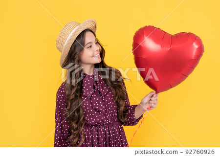 happy teen girl with red heart balloon on yellow background happy teen girl with red heart balloon on yellow background 92760926