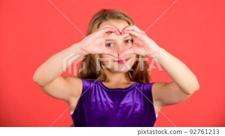 Celebrate valentines day. Love and sympathy. Love concept. Girl cute child show heart shaped hand gesture. Symbol of love. Kid adorable girl with long hair smiling face show heart gesture to you Celebrate valentines day. Love and sympathy. Love concept. Girl cute child show heart shaped hand gesture. Symbol of love. Kid adorable girl with long hair smiling face show heart gesture to you 92761213