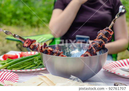 Cooked barbecue and vegetables with herbs on the table. 92761707