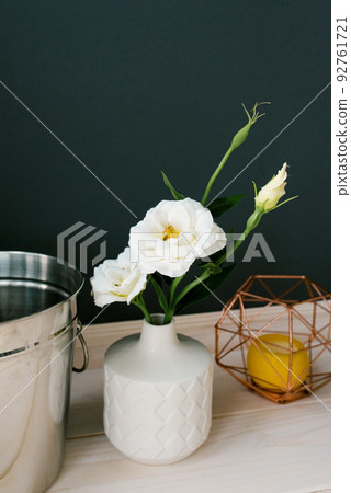 A white ceramic vase and an artificial white eustoma flower in it. Decor in the dining room or kitchen 92761721