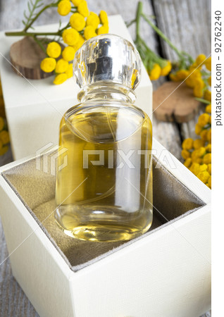 perfume bottles around yellow flowers at  wooden old style background . flat lay. perfumery concept 92762240
