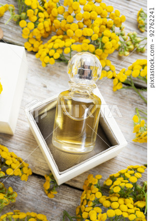 perfume bottles around yellow flowers at  wooden old style background . flat lay. perfumery concept 92762241