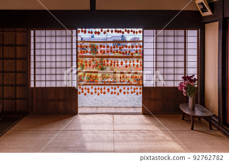 (Yamanashi Prefecture) Former Takano Family Residence (Kanko Yashiki) Persimmons in front of the eaves seen from the tatami room 92762782