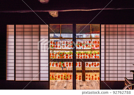 (Yamanashi Prefecture) Former Takano Family Residence (Kanko Yashiki) Persimmons in front of the eaves seen from the tatami room 92762788