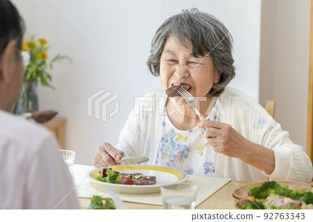 senior woman eating steak 92763343