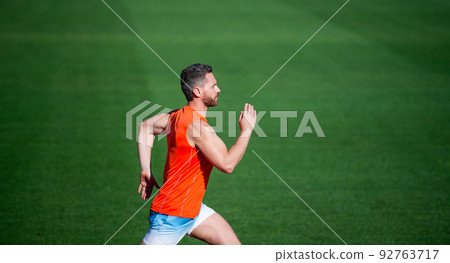 energetic man on running track. sporty runner. stamina. sport and endurance. outdoor stadium sprint. 92763717