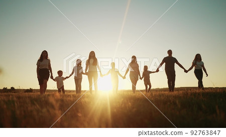community large family in the park. a large group of people holding hands walking silhouette on nature sunset in the park. big lifestyle family kid dream concept. people in the park. large family community large family in the park. a large group of people holding hands walking silhouette on nature sunset in the park. big lifestyle family kid dream concept. people in the park. large family 92763847