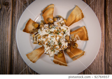 Oriental recipe aubergine and chickpea fatteh, pita, Greek yogurt, roasted pine nuts, zaatar 92764937
