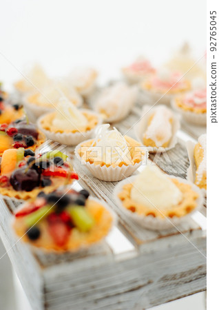 Variety of tasty appetizing sweet desserts with cream, berries and pastry, bakery and cakes on the grand wedding table at celebrate 92765045
