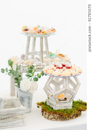 Variety of tasty appetizing sweet desserts with cream, berries and pastry, bakery and cakes on the grand wedding table at celebrate Variety of tasty appetizing sweet desserts with cream, berries and pastry, bakery and cakes on the grand wedding table at celebrate 92765070